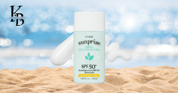 A close-up of the lightweight, green mint bottle of Sunprise sunscreen in a beautif Sand with blue ocean